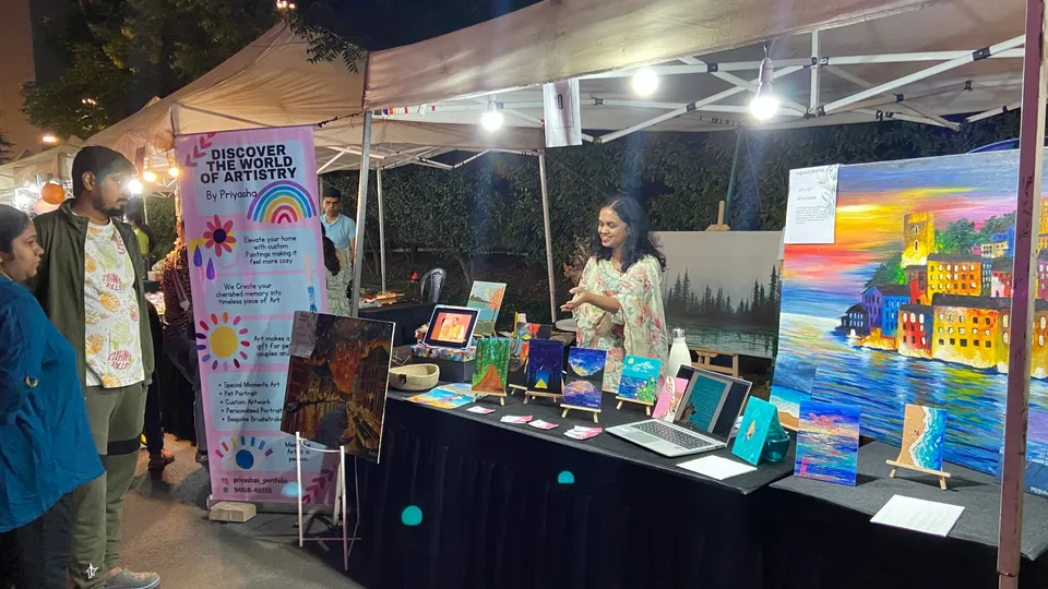 Sobha Art Booth 2023: artist speaking with booth visitors 1